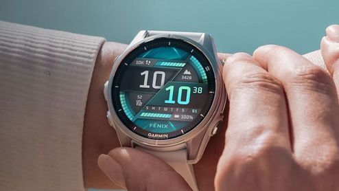 Primer plano de un reloj inteligente Garmin Fenix 8 en la muñeca con pantalla digital avanzada en tonos verdes y negros.