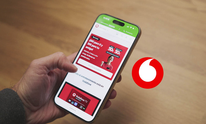 Mano sujetando un teléfono móvil que muestra la página web de Vodafone con una promoción del plan amigo.