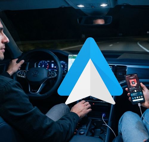 Icono de Android Auto sobreimpreso en el interior de un coche durante la conducción nocturna.