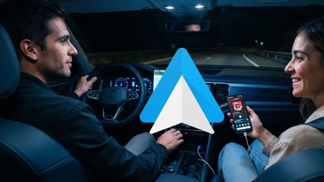 Icono de Android Auto sobreimpreso en el interior de un coche durante la conducción nocturna.