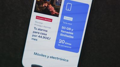 Primer plano de un teléfono móvil mostrando ofertas de tarifas de fibra, móvil y alarmas de Movistar en su aplicación oficial.