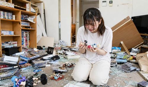 Chica lamentándose por su colección rota de figuras