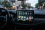 Pantalla de infoentretenimiento en el salpicadero de un coche mostrando la interfaz de Android Auto con iconos de aplicaciones y juegos.
