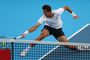 Rafael Jódar realizando un golpe de derecha en una pista de tenis azul tras un desplazamiento lateral.
