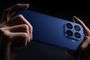 Parte trasera de un smartphone Xiaomi azul mostrado horizontalmente con ambas manos, destacando su módulo de cuatro cámaras cuadradas.