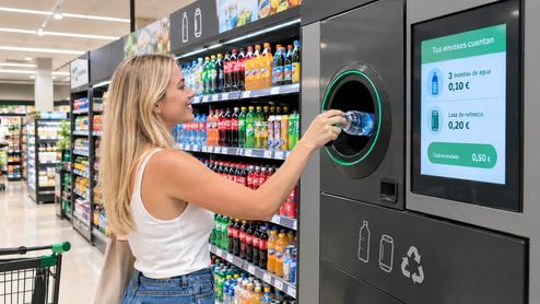 Una chica reciclando en una máquina de envases