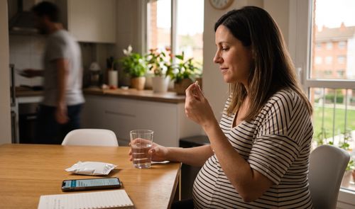 Ilustración conceptual de una mujer embarazada sosteniendo un comprimido, representando el uso de paracetamol durante la gestación