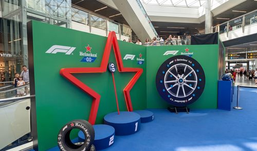 Vista general del espacio Heineken 0.0 Paddock en el centro comercial La Vaguada de Madrid, con simuladores de conducción y decoración de Fórmula 1