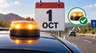 Luz de emergencia V16 encendida sobre el techo de un coche con un calendario al fondo marcando el 1 de octubre.