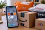 Teléfono inteligente con aplicaciones de compras abiertas junto a paquetes de Amazon, AliExpress, Temu, SHEIN y eBay identificados como 29T095045.