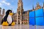Figura de Tux frente al Ayuntamiento de Múnich junto al logotipo de Windows.
