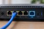 Panel trasero de un router con cable Ethernet azul conectado y puerto de alta velocidad resaltado