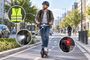 Usuario en patinete eléctrico circulando por un carril bici con señalizaciones sobre elementos de seguridad como chaleco reflectante y luces.
