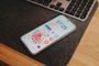 Smartphone Android con pantalla de inicio personalizada sobre una alfombrilla de escritorio junto a un teclado.