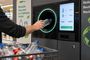 Persona introduciendo una botella de plástico en una máquina de reciclaje con sistema de depósito y retorno.