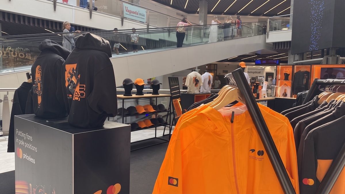 Interior de la tienda pop-up oficial de McLaren Mastercard Formula 1 Team en La Vaguada, mostrando el merchandising del equipo y de los pilotos Lando Norris y Oscar Piastri