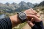 Primer plano de una persona consultando un mapa en su reloj inteligente Garmin Fenix durante una ruta por la montaña.