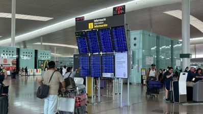 Pasajeros consultando los paneles informativos de vuelos en la terminal de un aeropuerto.