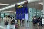 Pasajeros consultando los paneles informativos de vuelos en la terminal de un aeropuerto.