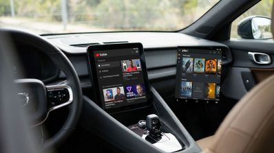 Pantalla central de un coche Volvo ejecutando la aplicación de YouTube junto a una interfaz de Plex.