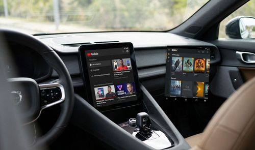 Pantalla central de un coche Volvo ejecutando la aplicación de YouTube junto a una interfaz de Plex.