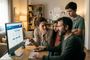 Familia de cuatro personas con expresión de duda mirando la web oficial de DIGI en un ordenador de sobremesa.