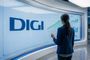 Una analista frente a una gran pantalla que muestra el logotipo de Digi y diversos gráficos de crecimiento de datos.