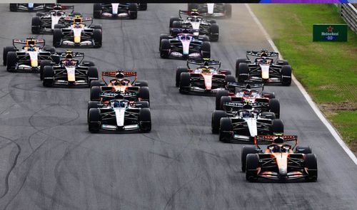 Gran grupo de monoplazas de Fórmula 1 compitiendo en pista durante una carrera.