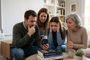 Cuatro personas de distintas generaciones miran con preocupación y frustración un teléfono móvil que muestra un test de velocidad de red.