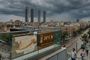 Infografía sobreimpresionada de la AEMET con datos de temperatura en Madrid bajo un cielo nublado y tormentoso sobre las Cuatro Torres.