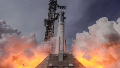 Lanzamiento de un cohete espacial de gran tamaño rodeado de nubes de humo y fuego en la base.