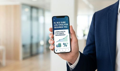 Mano de una persona en traje sosteniendo un smartphone que muestra una noticia sobre la subida de tipos del BCE y su impacto en cuentas remuneradas.