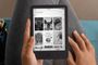 Primer plano de una persona sosteniendo un lector electrónico Kindle con la biblioteca de libros digitales en pantalla.