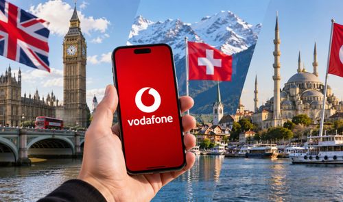 Mano sosteniendo un teléfono móvil con el logotipo de Vodafone frente a paisajes de Londres, Suiza y Turquía.