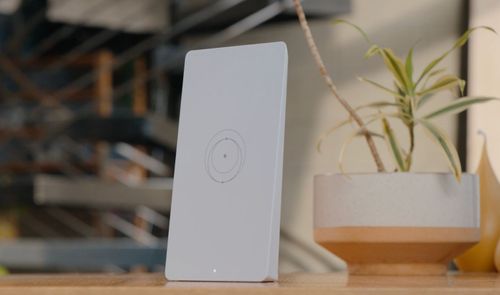 Router inalámbrico WiFi 7 de color blanco con diseño rectangular minimalista colocado sobre un mueble de madera.