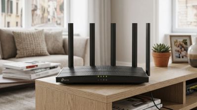 Router TP-Link de color negro con seis antenas externas sobre un mueble de madera en un salón.
