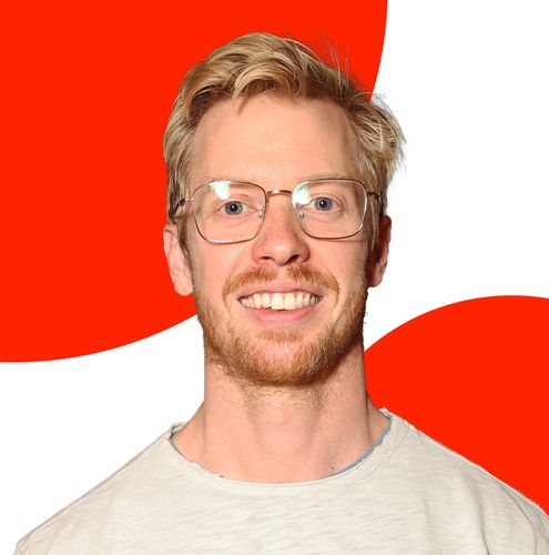 Retrato de Steve Huffman con gafas y barba sobre un fondo de formas circulares rojas.