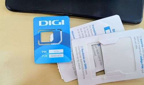 Tarjeta SIM de DIGI sobre una superficie plana junto a las instrucciones de portabilidad y activación.