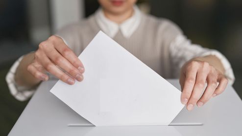 Metiendo un sobre para votar