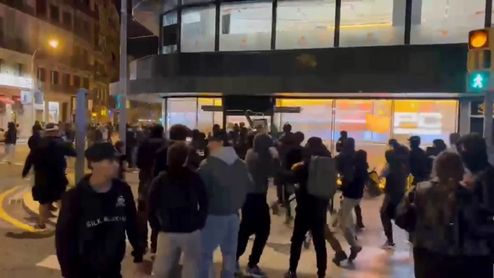 Multitud de personas concentradas frente a la entrada de la tienda PcComponentes en Barcelona durante la noche.