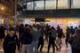Multitud de personas concentradas frente a la entrada de la tienda PcComponentes en Barcelona durante la noche.