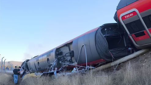 Vagón de un tren iryo volcado lateralmente sobre un terraplén tras un descarrilamiento.