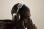 Perfil de un hombre con los auriculares airpds-max-2 puestos y los ojos cerrados.
