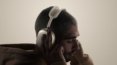 Perfil de un hombre con los auriculares airpds-max-2 puestos y los ojos cerrados.