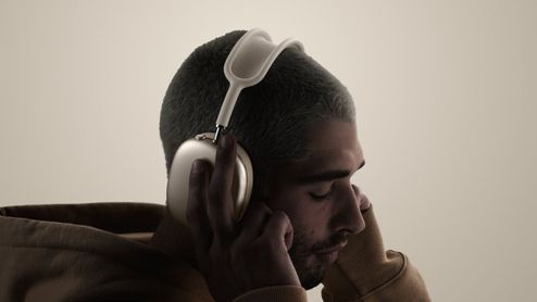 Perfil de un hombre con los auriculares airpds-max-2 puestos y los ojos cerrados.