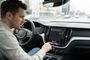 Conductor mirando con confusión la pantalla central de un coche con un mensaje de error o desconexión