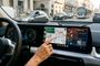 Interfaz de Android Auto en la pantalla táctil de un coche BMW circulando por ciudad.