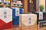 Varias cajetillas de tabaco con precinto fiscal y códigos QR sobre el mostrador de un estanco.