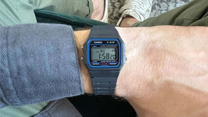 Reloj digital Casio F-91W puesto en una muñeca mostrando la hora y los botones laterales de configuración.