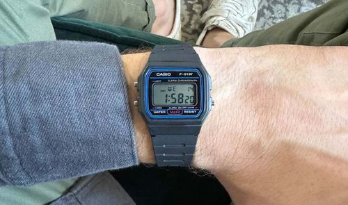 Reloj digital Casio F-91W puesto en una muñeca mostrando la hora y los botones laterales de configuración.